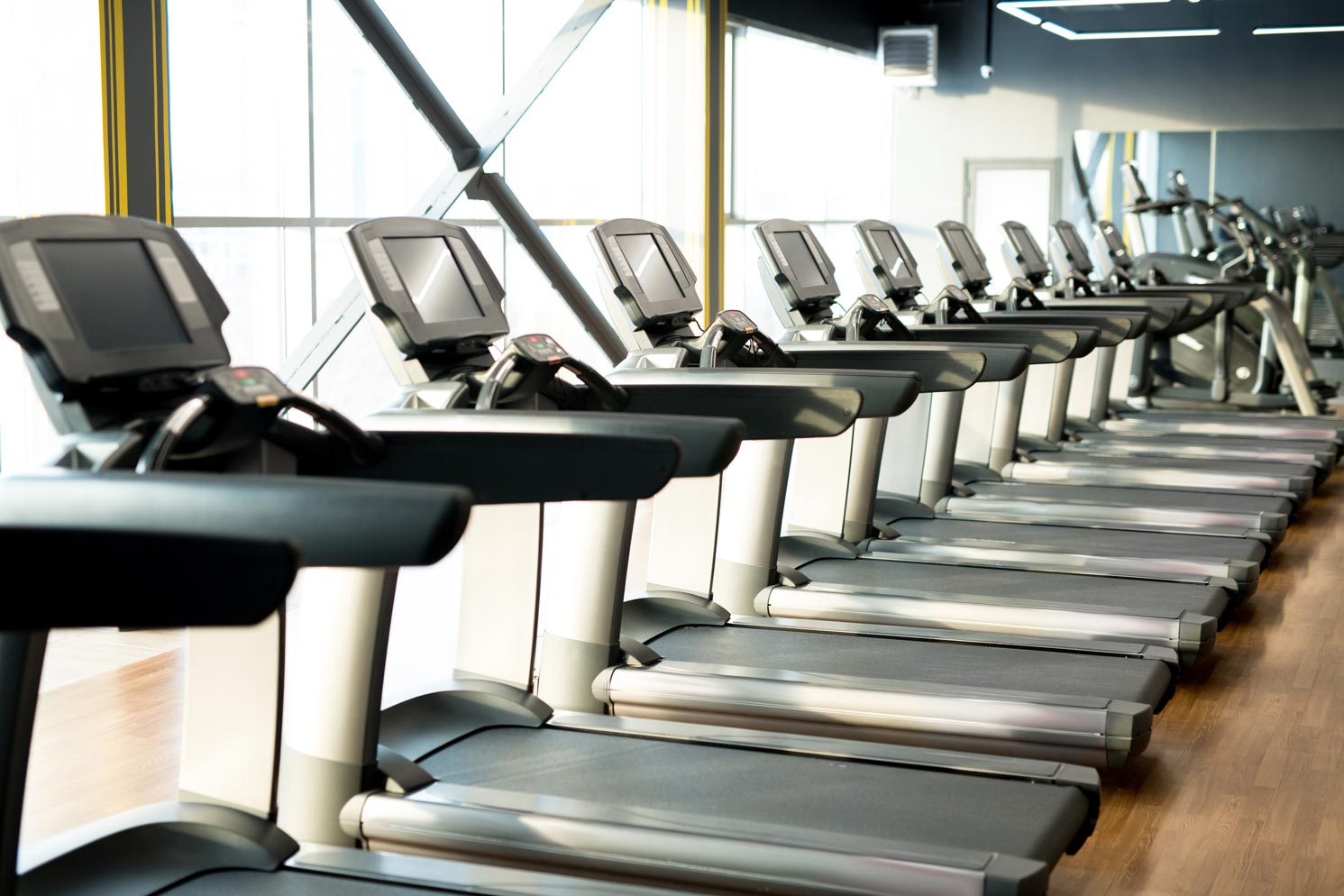 Fitness club with row of treadmills for fitness cardio exercises