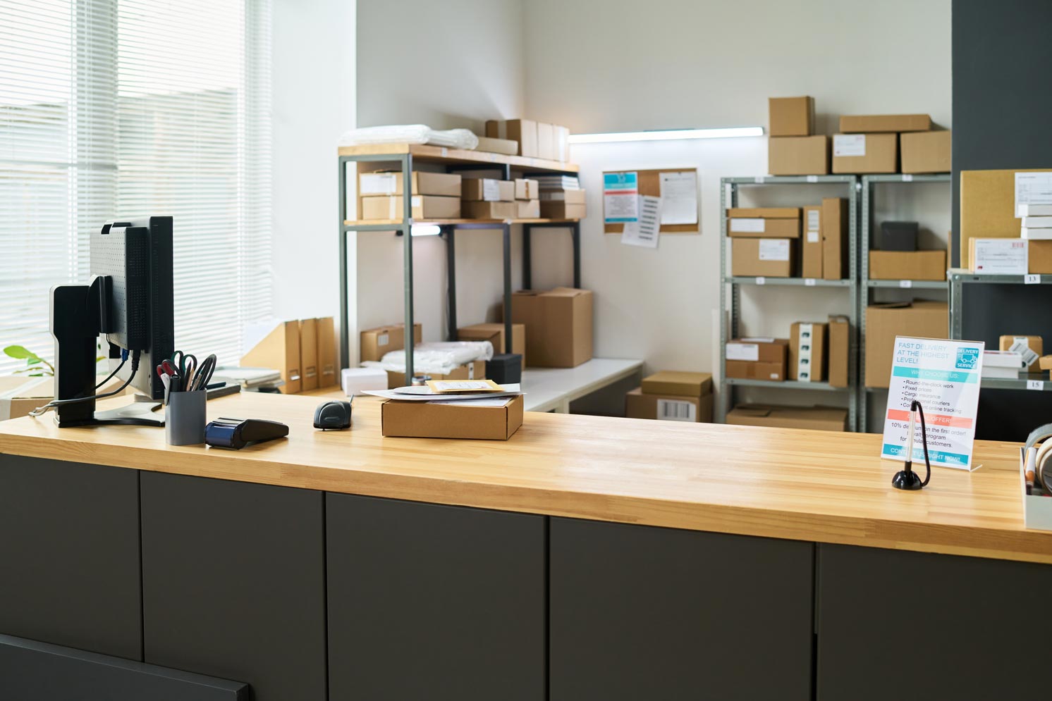Empty modern mailroom counter displaying cardboard package on wooden surface