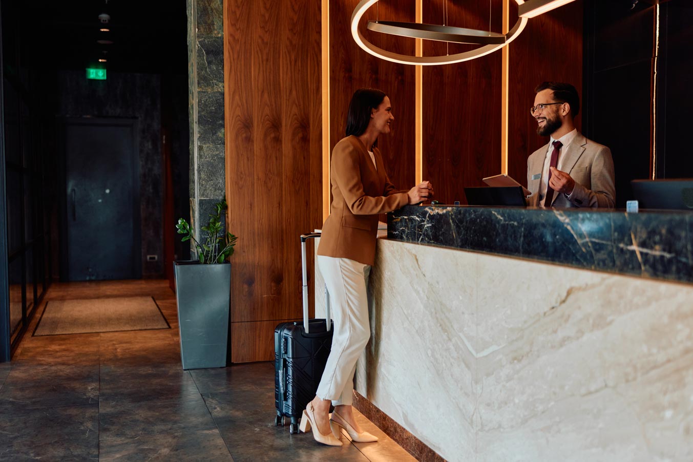 Businesswoman checking into hotel reception with concierge