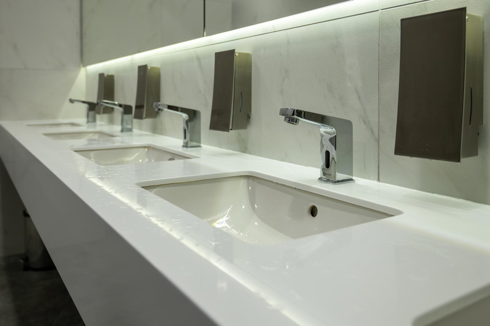 Clean white ceramic washbasins with touchless sensor faucets